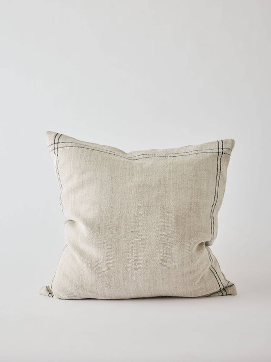 Beige pillow with dark stitching on a light gray background