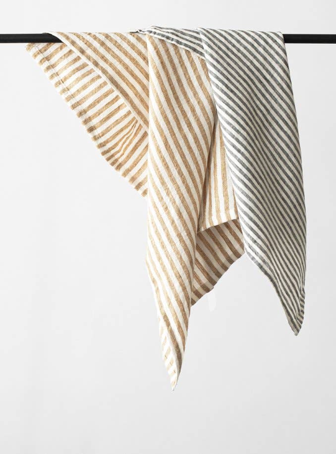 Striped tea towels on a rod against a white background