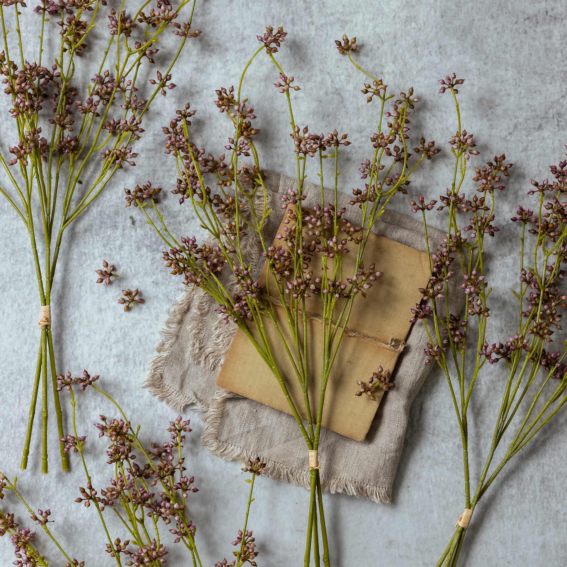 Dried lavender flowers with a wooden spoon on a textured surface
