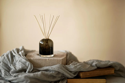 Decorative diffuser with sticks on a textured surface with a neutral background