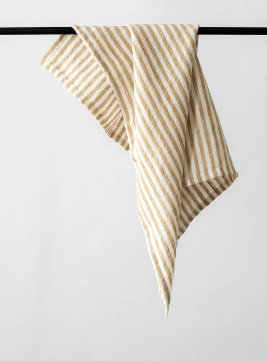 Striped tea towel hanging on a black rod against a white background